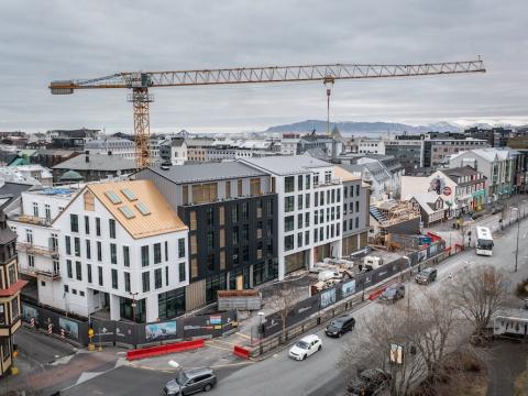 Houses, construction crane, street and cars.