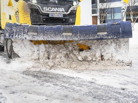 a snow plow driving on a street.
