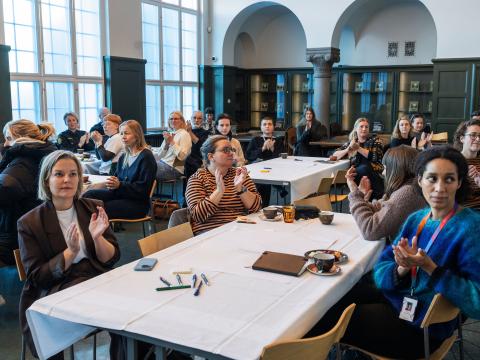 Fá málþingi um öryggi hinsegin fólks í Safnahúsinu 29.okt 2025. Fólk við borð í sal.
