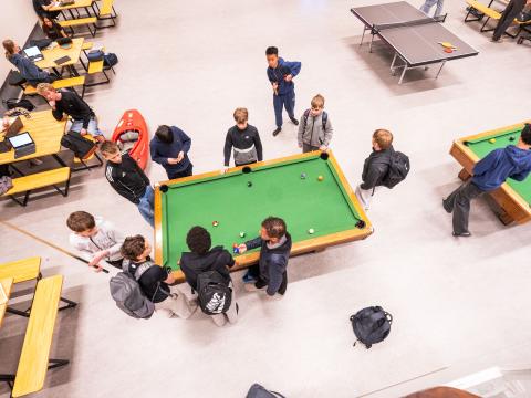 Unglingar í frímínútum í Ölduselsskóla, tekið ofan á þau að spila pool á grænu borði