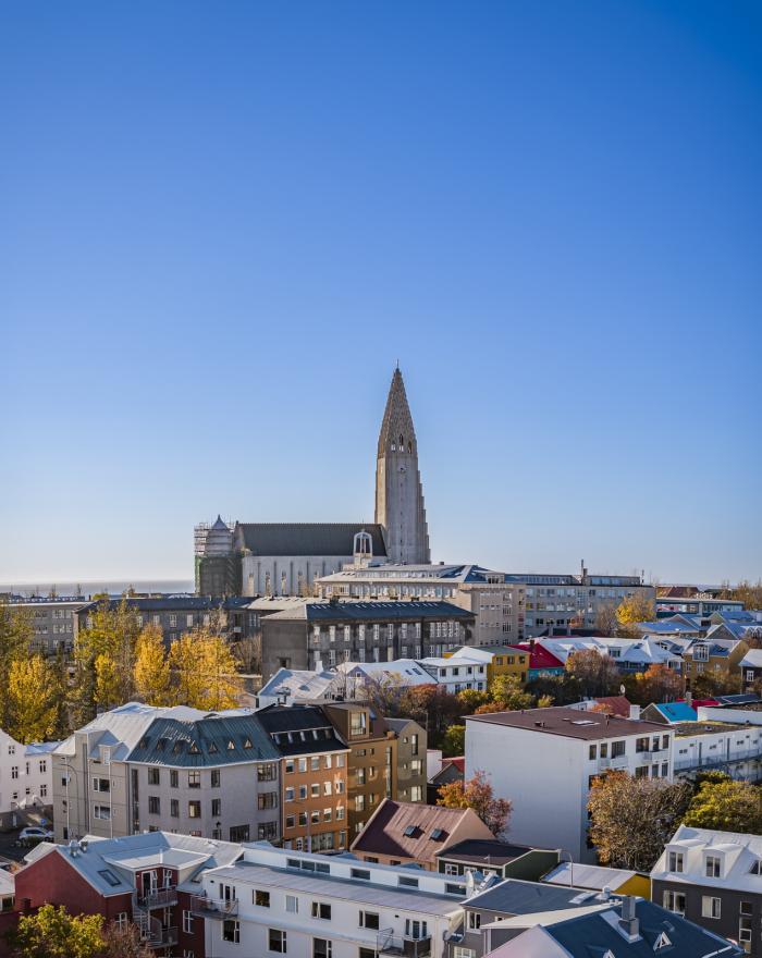 Mynd af húsum og Hallgrímskirkju. Blár himinn.
