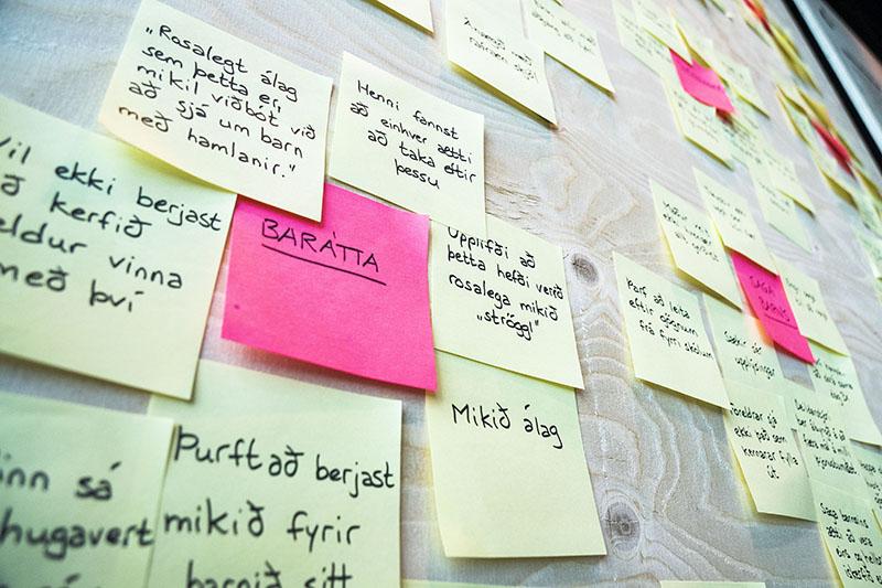Mynd af post-it miðum á vegg í þemagreiningu.