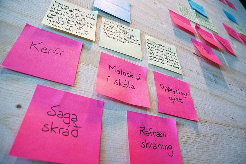 Mynd af post-it miðum á vegg í þemagreiningu.