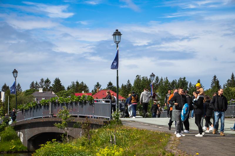 Fólk gengur yfir brúnna að Hljómskálagarði