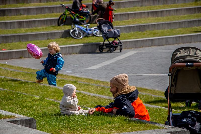 Faðir leikur við barnið sitt í grasinum á Klambratúni