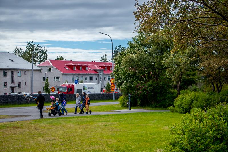 Klambratún í átt að miklubraut. Fjölskylda gengur eftir göngustígnum