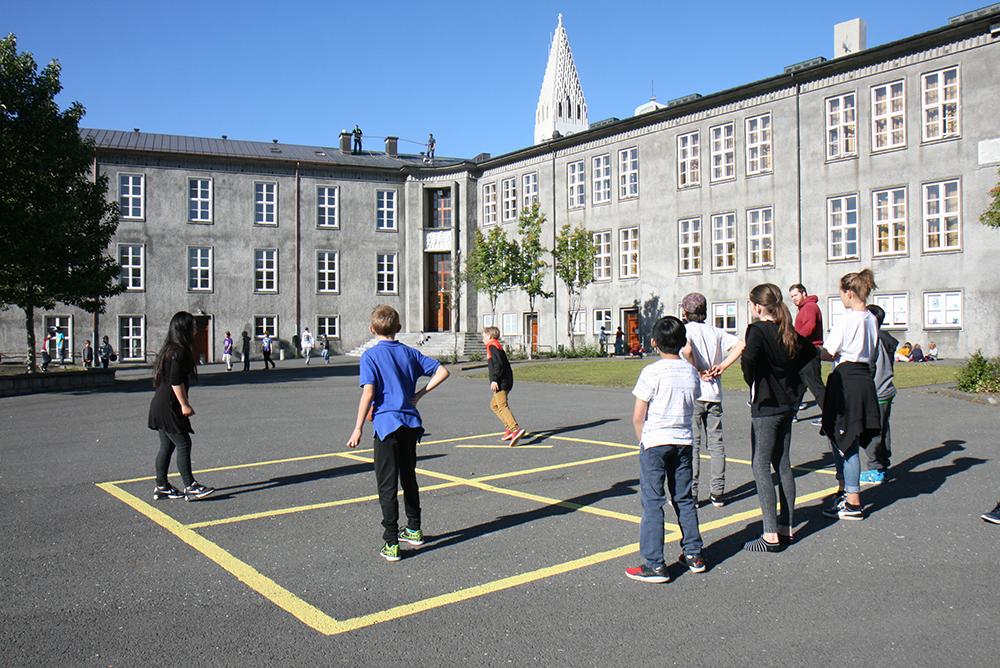 Children playing pogo on the grounds of Austurbæjarskóli.