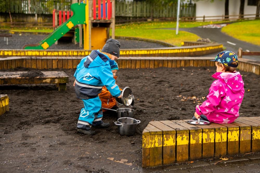 Börn að leika sér í sandkassa á útisvæði leikskólans Björtuhlíðar