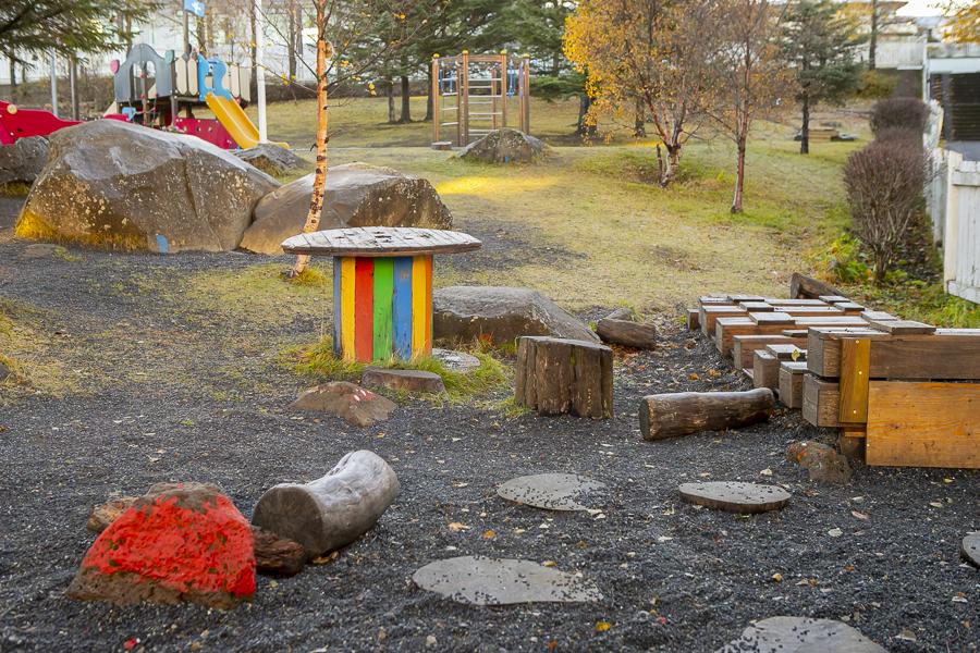 Tree logs, painted rock and outdoor toys in Brekkuborg's outdoor area