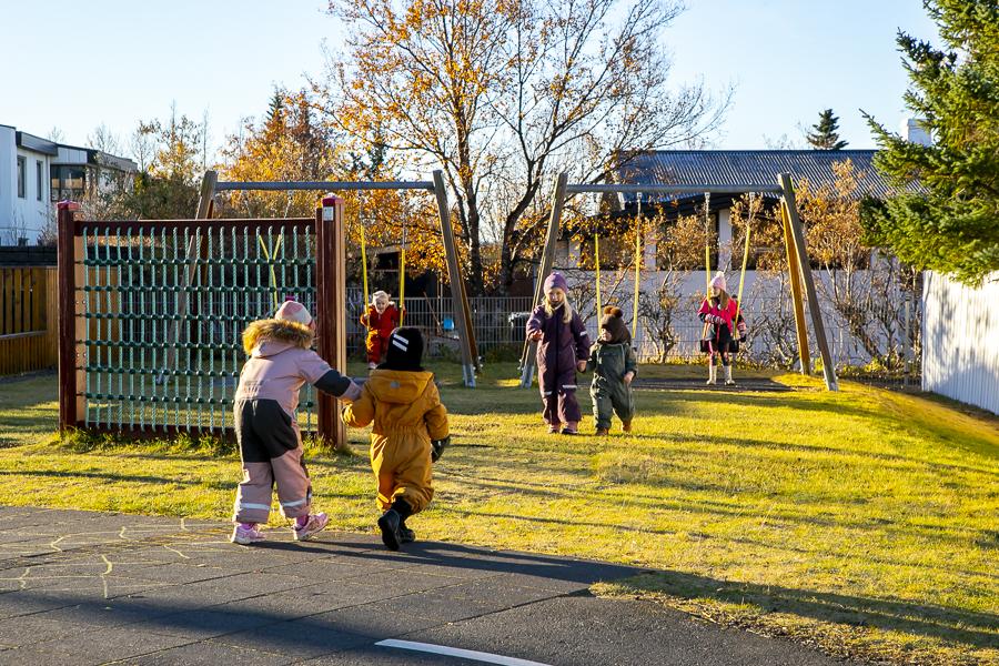 Children and playground equipment on Heiðarborg's grounds.