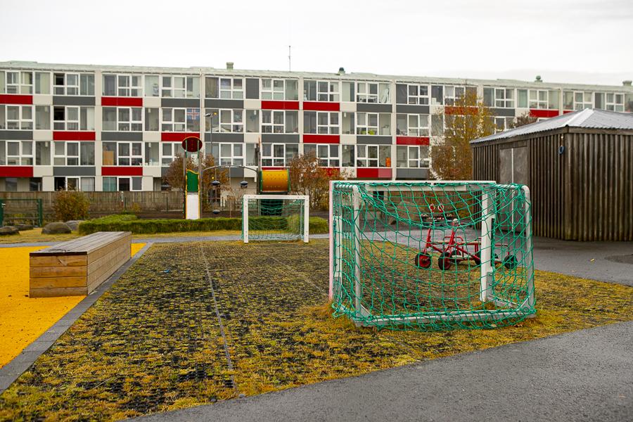 Fótboltavöllur og leiktæki á lóð Aspar.