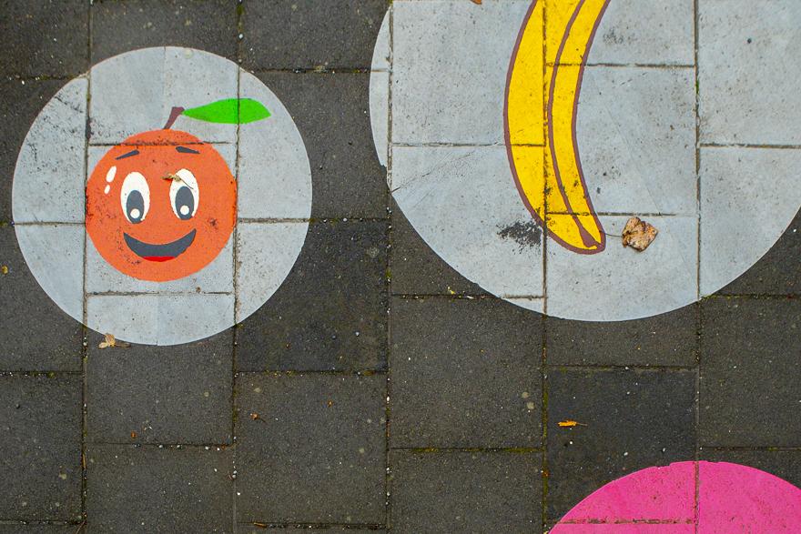 Myndskreytingar af epli og banana á stétt leikskólans Hlíðar við Eskihlíð