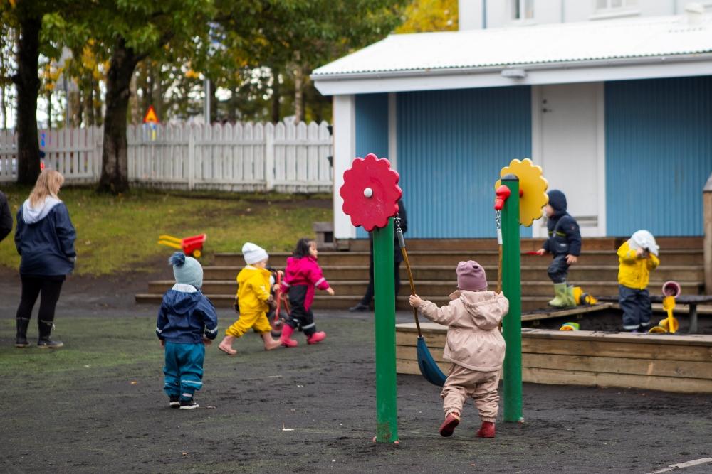 Börn að leik í marglitum útigöllum á útilóð leikskólans Miðborgar við Barónsstíg