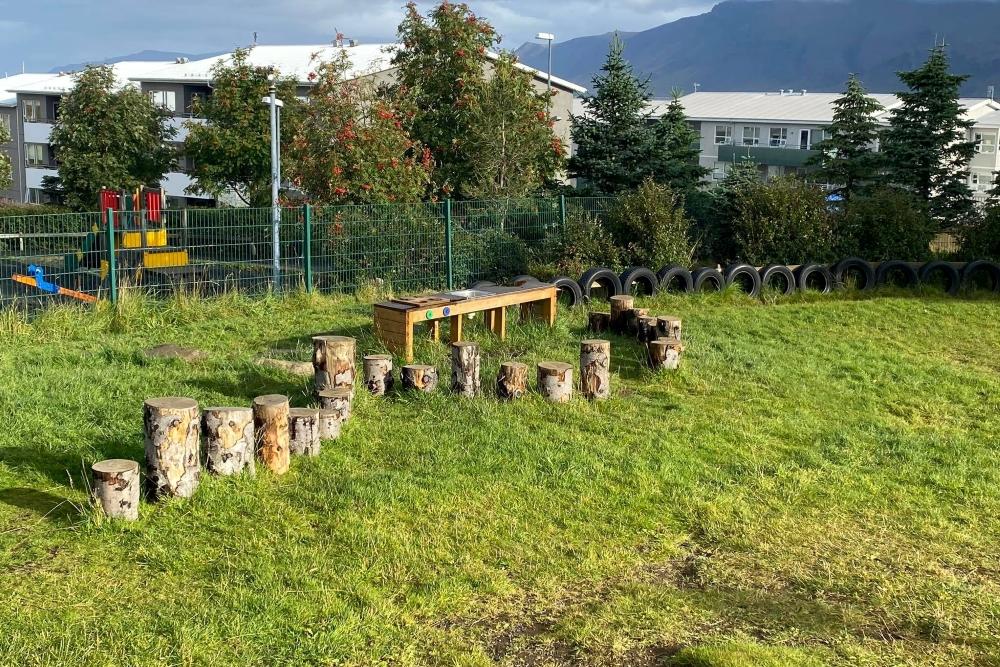 Trjádrumbar og bíldekk á útisvæði leikskólans Ness