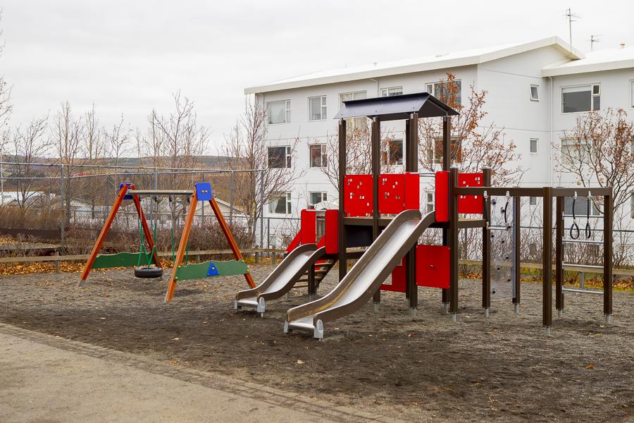 Playground castle with slides and swings in the outdoor play area at Sunnufold preschool