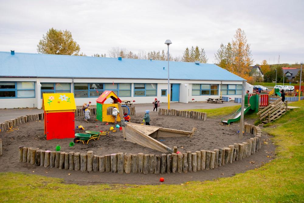 Sandkassi og leiktæki á lóð Jöklaborgar.
