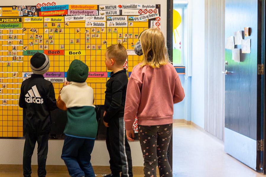 Children looking at the schedule board for Álfheimar after-school program.