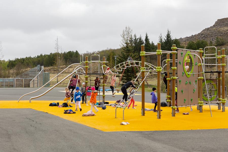 Klifurgrind á gulu undirlagi og börn að leik. 