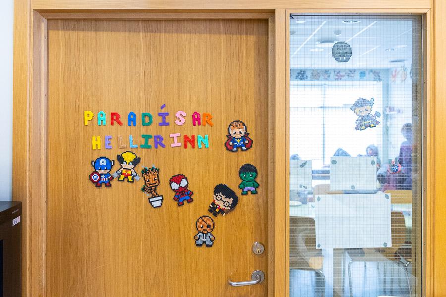 Door decorated with beaded pictures and beaded letters spelling out "Paradise Cave" in Icelandic.