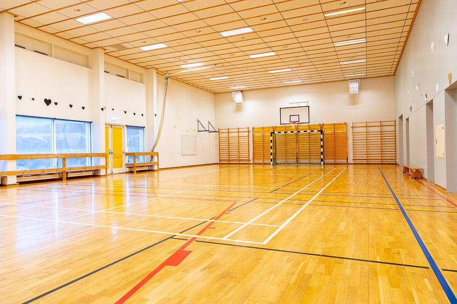 Íþróttasalur með fótboltamarki og körfuboltakörfum. 