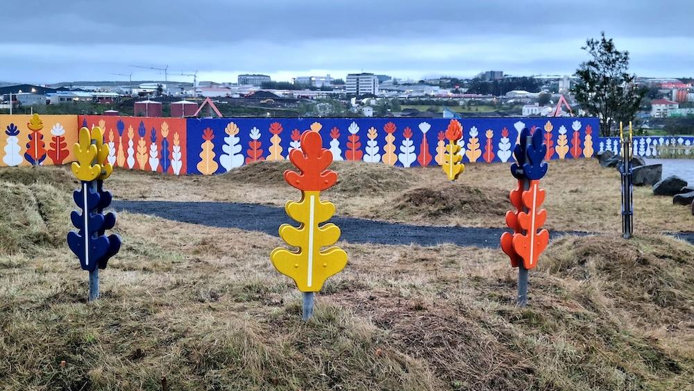 Litríkir skúlptúrar, málaður veggur og gras.