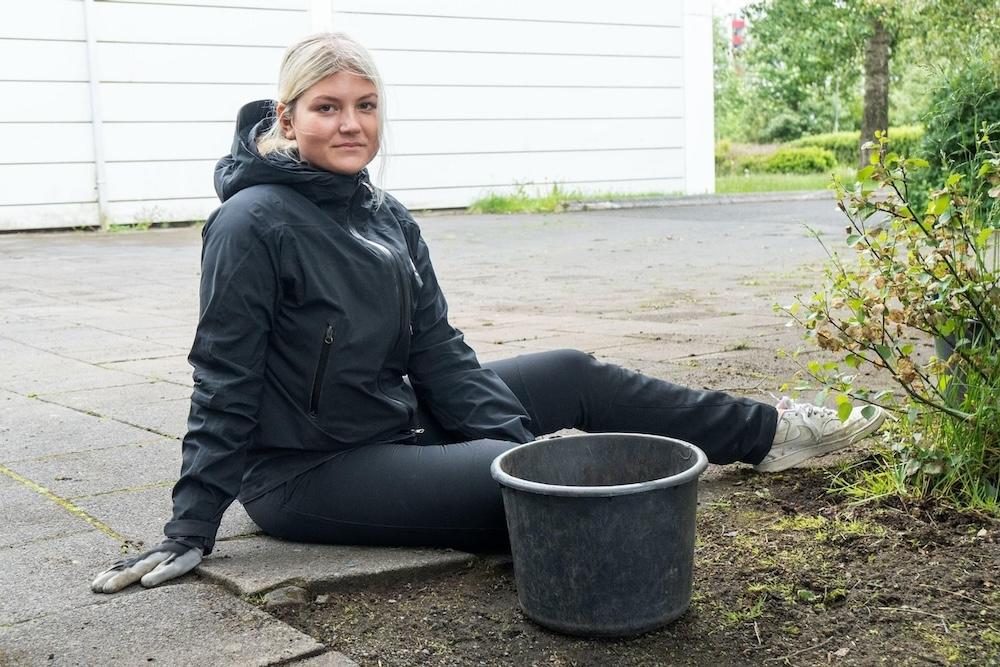 Gras, mold, stétt. Kona með fötu.