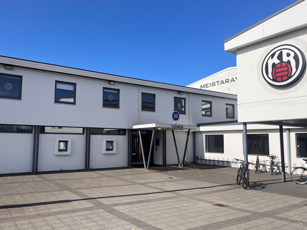 Ljósmynd af hvítu húsi með skilti sem á stendur Tjörnin. Stórt KR merki á hægri hlið hússins. 