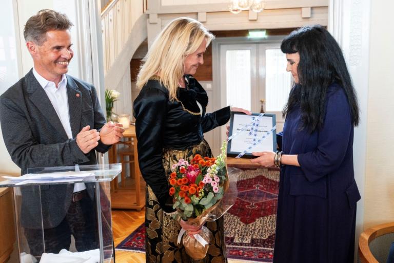 Ragnhildur Gísladóttir borgarlistamaður Reykjavíkur tekur við heiðursskjali og blómum sem Heiða B. Hilmisdóttir borgarstjóri afhenti henni í athöfninni í Höfða í dag.