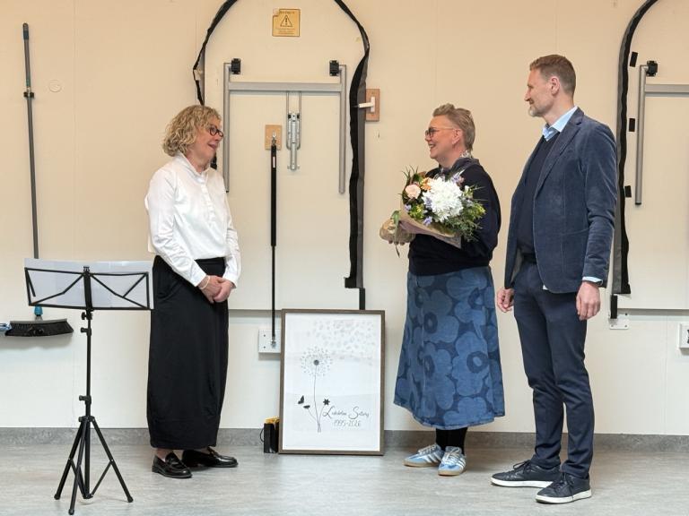Regína tekur við blómum frá Gyðu Guðmundsdóttur fagstjóra og Steini Jóhannssyni sviðsstjóra.