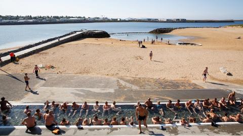 View over the hot tub, the warm beach and out to Fossvogur