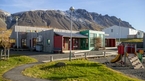 Leikskólinn Berg og leiktæki á lóðinni.