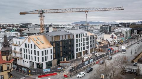 Houses, construction crane, street and cars.